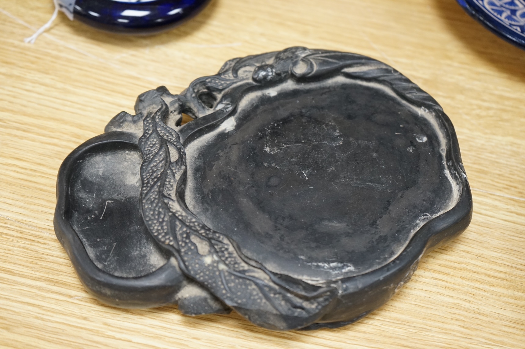 A Chinese carved inkstone, character marks to the base, 23cm